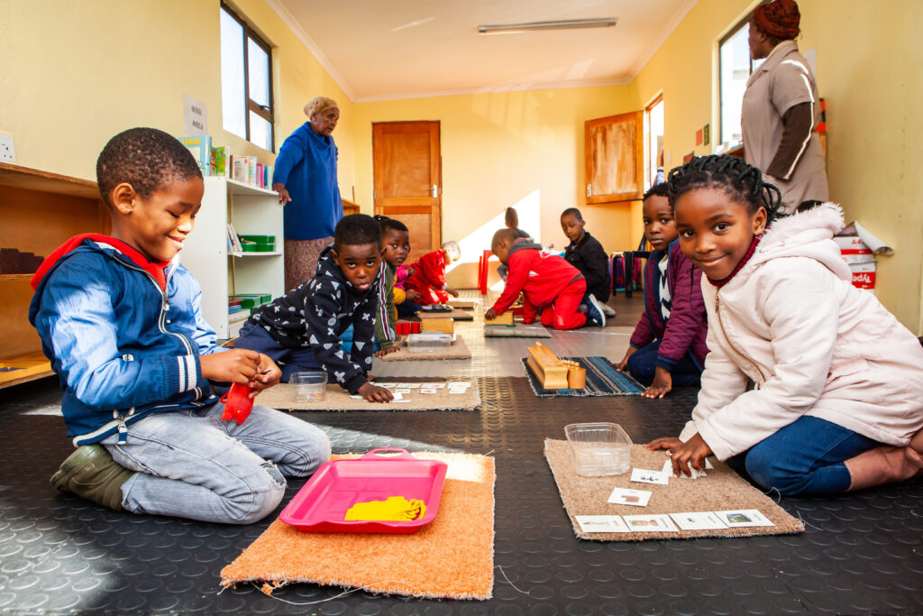 Children on the floor playing with Montessori toys