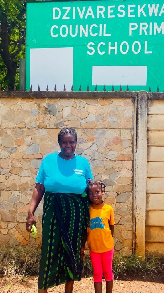 Loice and her grandmother Rose in front of Loice's new school